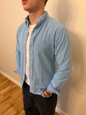 Ljusblå Polo Ralph Lauren skjorta - En snygg polo skjorta som passar till alla tillställningar! Du ska kunna uttrycka stil utan att det kostar för mycket!🕺🍾💼🤩  Storlek👔: M Nypris💰:  ca 1399 kr