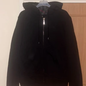 Svart Burberry hoodie  - Svart Burberry kofta som håller dig varm och stilfull hela vintern. Tillverkad i mjukt, högkvalitativt material med klassiska Burberry detaljer som gör den både skön att bära och enkel att matcha.