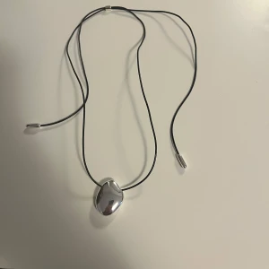 Silvrigt halsband med svart snöre  - Snyggt och coolt halsband som jag aldrig har andvänt 😋köpt från other stories och perfekt nu till hösten o våren! Köpt för ung 350 kr i butik, aldrig andvänt 