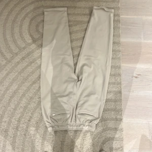 Beige mjukisbyxor med resårmidja - Snygga beige mjukisbyxor med elastisk midja och raka ben. Byxorna har sidfickor och är tillverkade i ett mjukt material som känns skönt mot huden. Perfekta för en chill och avslappnad stil. Mycket sköna och old money stil