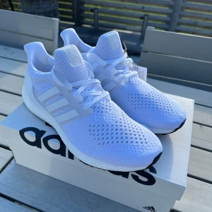 Adidas Ultraboost 1.0 helvita löparskor - Säljer ett par Adidas Ultraboost 1.0 i helvitt. Helt nya, aldrig använda. Storlek 43 1/3. Normal i storlekarna. Skorna har stickad ovandel i primeknit. Ultraboostsula för bra dämpning. Produktkod HQ4202. 