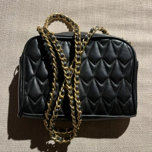 Väska  - En liten och skit snygg svart läder väska med guldiga detaljer, fräsch och inga slitningar🖤⚜️