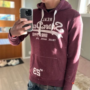 Superdry hoodie - |Tja! En otroligt snygg spuerdry hoodie en skön vinröd färg ❗️| Skick 8/10 bra skick☑️| Storlek: M, sitter mer som XS/S - jag är 189cm 73kg och sitter lite litet på mig📏| Nypris: ca 1000kr💵| Färg: vinröd, som på bilden❤️ | Fraktar spårbart via postnord eller instabox📦| Hör av er för mer information!|