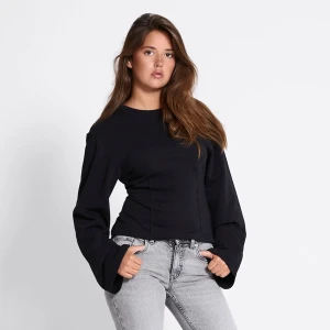 Svart långärmad tröja med vida ärmar - Säljer en svart långärmad tröja med rund hals och vida ärmar. Den är helt ny med prislappen kvar. Säljer på grund av att den inte passar. 