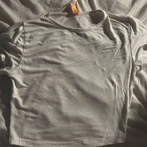 Vit croppad topp från Top&Hot - Enkel och stilren vit croppad topp från Top&Hot. T-shirtdesign med rund halsringning och korta ärmar. Perfekt att matcha med jeans eller kjol för en clean look. Mjuk och skön i bomullsmaterial.