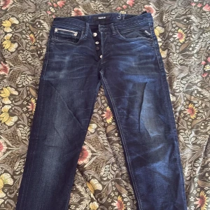 Replay jeans blå straight fit - Snygga blå jeans från Replay med klassisk femficksdesign och knappgylf. Jeansen har en straight fit. Perfekt för dig som gillar stilrena och bekväma jeans. 