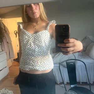 Vit prickig topp - Vit prickig topp i linnetyg, den är i storlek M men jag har själv sytt in den i midjan och i banden så den ska passa mig som i vanskliga fall har xs-s men man kan ju självklart lätt sprätta upp de. Den är knappt använd.💕