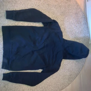 Mörkblå hoodie från Sail Racing S - Mörkblå hoodie från Sail Racing med hel dragkedja och broderad logga på bröstet. Tröjan har huva, långa ärmar och är tillverkad i mjuk bomullsmix. Perfekt för chill dagar eller när du vill ha en clean och sportig look.