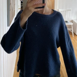 Mörkblå stickad tröja från 157 - Mysig mörkblå stickad tröja från 157 med rund halsringning och avslappnad passform. Perfekt för lager-på-lager och chill dagar. Långa ärmar och ribbade muddar ger en enkel men snygg look.