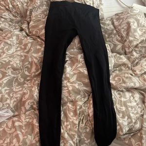 Svarta höga leggings - Svarta leggings med låg midja och tight passform. Perfekta för träning eller chill, de är stretchiga och sitter skönt mot kroppen. Materialet känns mjukt och följsamt. Enkla att matcha med oversized hoodie eller crop top.