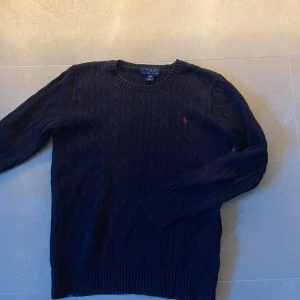 Stickad Polo Ralph Lauren tröja  - Säljer en stilren stickad Polo Ralph Lauren tröja. Perfekt nu i hösten, den är helt perfekt skick inget fel med den. Storlek XL själv är jag 180 och den passar mig som man ser på bilden jag bär själv M så jag skulle inte säga att den är XL