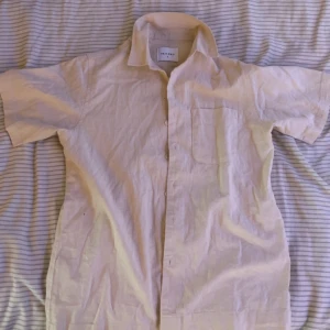 Beige kortärmad skjorta från Vailent - Snygg beige skjorta från Vailent i storlek S. Skjortan har korta ärmar, klassisk krage, bröstficka och knappar framtill. Perfekt för dig som gillar enkel och clean stil. Materialet känns lätt och luftigt, perfekt för varmare dagar, Har aldrig använt. 