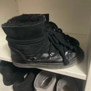 Svarta boots från Inuikii med snörning - Säljer ett par svarta boots från Inuikii med grov snörning och rund tå. Skorna är fodrade med mjukt material på insidan och har en kombination av skinn och mocka på utsidan. Perfekta för kalla dagar och ger en cool vinterlook.