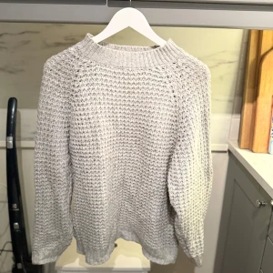 Ljusgrå stickad tröja - Säljer en ljusgrå stickad tröja som är från Lager 157. Tröjan har långärmad passform och är perfekt för kyliga dagar.