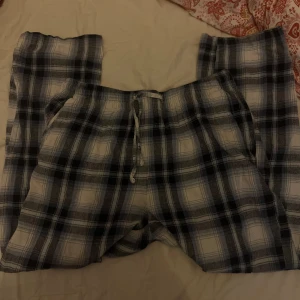 Rutiga pyjamasbyxor med snörning - Mysiga pyjamasbyxor i blått och vitt rutigt mönster. Byxorna har resår i midjan och snörning framtill för extra komfort. Perfekta för chill dagar hemma. Tillverkade i mjukt bomullstyg.