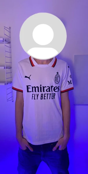 AC Milan vit bortatröja Puma Theo 19 - AC Milan bortatröja i vitt med svarta och röda detaljer, Puma-logga och sponsortryck. Nummer 19 och Theo på ryggen. Korta ärmar med röd och svart kant. Tillverkad i lätt och ventilerande material, perfekt för match eller träning.