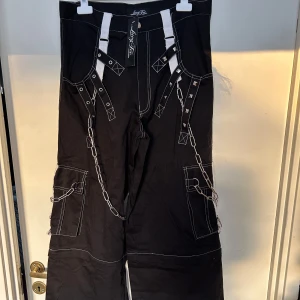Rockiga byxor från Lucyfer storlek XS. Avtagbara till shorts - Helt nya hårdrocksbyxor. Storlek XS. Avtagbara till shorts. Material i skön bomull. Ordpris 995kr.