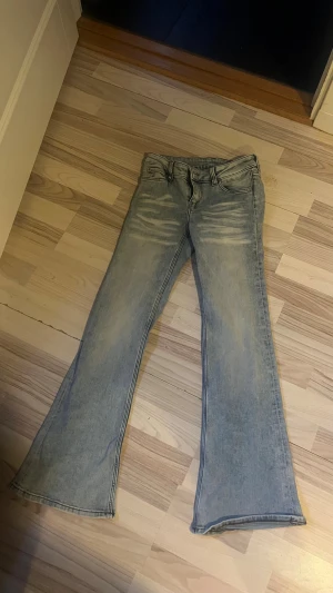 Bootcut jeans från Cheap Monday - Snygga ljusblå bootcut jeans från Cheap Monday med slitningar framtill och klassisk femficksdesign. Jeansen har en stor vit patch med Cheap Monday-loggan bak och är tillverkade i mjukt denimtyg. Perfekt för dig som gillar retrovibbar och breda ben dem är heller aldrig andvända💕