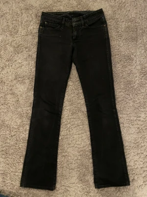 Lågmidjade bootcut jeans - Snygga svarta lågmidjade bootcut jeans från märket Wrangler. Midjemått: 36cm, innerbenslängden: 80cm. Skriv vid frågor❤️❤️