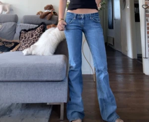 Lågmidjade jeans - Supersnygga Lågmidjade bootcut jeans från Garage. Helt i original, ej omsydda eller rörda. I jättefint skick trots vintage, inga slitningar. Midjemått tvärsöver: 25cm. Innerbenslängd: 79cm. Säljer då de är för långa på mig