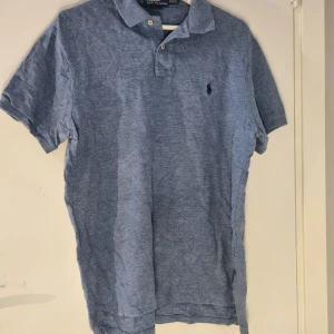 Ralph Lauren pike - Säljer en klassisk pikétröja från Ralph Lauren med korta ärmar. Perfekt för en stilren och avslappnad look.            