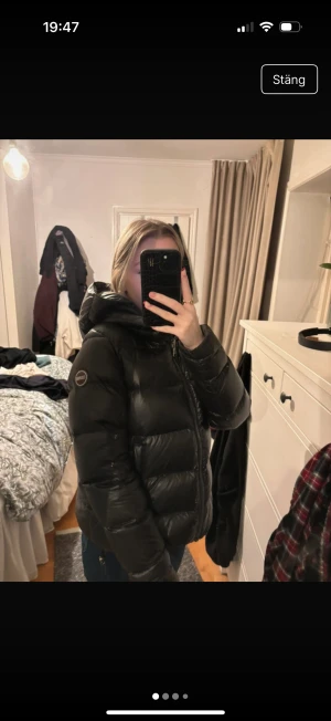 Svart Colmar pufferjacka med huva - Säljer en svart pufferjacka från Colmar med stor, mysig huva och markerad logga på ärmen. Storlek S. Den är i väldigt bra sick