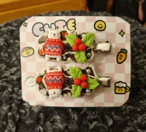 Söta juliga hårspännen  - Ett par hårspännen dekorerade med gulliga björnar i röda stickade tröjor, gröna blad och röda bär. Spännena har pärlor och små blommor i plast, Perfekt för dig som gillar kawaii och juliga accessoarer. Längd 5,5 cm 