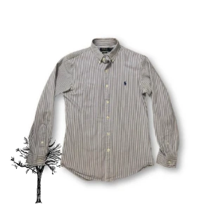 Randig skjorta från Polo Ralph Lauren | slim fit - Snygg klassisk skjorta från Polo Ralph. Skjortan har lång ärm, knappar framtill och den ikoniska broderade loggan på bröstet. Perfekt för dig som gillar stilrena och tidlösa plagg.