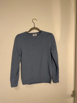 Blå stickad tröja från Bläck - En blå stickad tröja från Bläck i storlek S. Tröjan har rund halsringning, ribbade muddar och långärmad design. Materialet är mjukt och skönt mot huden. En skön och snygg blå stikad tröja! Kostar runt 600kr ny