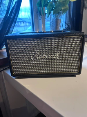 Marshall Acton Bluetooth-högtalare - Marshall Acton är en kompakt Bluetooth-högtalare med klassisk design, tydliga reglage för volym, bas och diskant. Högtalaren är i gott skick med mindre spår av användning. Perfekt för musikälskare som vill ha kraftfullt ljud och ikonisk stil i hemmet.