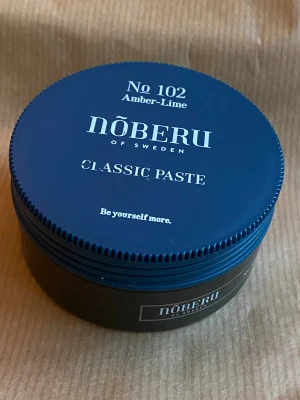 Nõberu Classic Paste No. 102 – Amber/Lime (80 ml) - Säljer en Classic Paste från Nõberu of Sweden i doften Amber–Lime. Ger naturlig stadga och matt finish – perfekt för både kort och halvlångt hår.  ✔️ oanvänd (se bild) ✔️ Fräsch doft ✔️ Nypris ca 199 kr  Mitt pris: 60 kr  ✨ Passar även som julklapp!