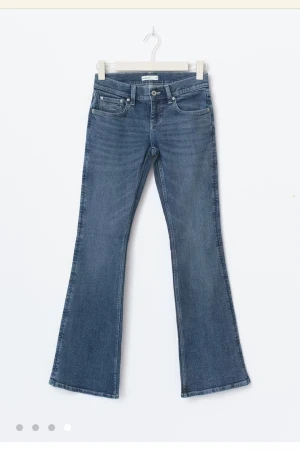 Low waist bootcut jeans - Lågmidjade bootcut jeans med figurnära passform. Jeansen är blåa och har utsvängda ben med normallängd. De har stretchig kvalitet, dragkedjegylf, bälteshällor och fickor fram och bak. Se gärna vår storleksguide för att hitta din storlek. Köpt till fullpris 499kr