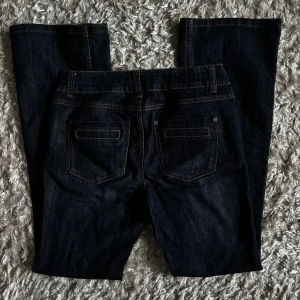 Midwaist bootcut jeans - Bootcutjeans med medelhög midja i mörkblått. Supersnygga fickor också!