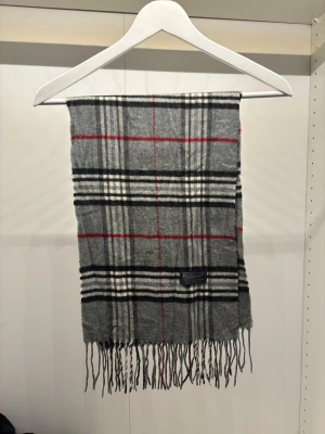 Vintage Burberry Halsduk Scarf - -Riktigt bra skick. Nypris på dessa ligger på runt 5000kr, vilket gör detta till ett sjukt bra pris! Halsduken är gjord i Lamull, och är perfekt inför hösten och den kommande vintern. Anledningen till att det står ”Burberry’s” och inte ”Burberry” på lappen är eftersom halsduken är från några år tillbaka, innan de bytte namn! Om du har någon fråga är det bara att skriva till mig. /elgnce 