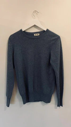 Blå kashmirtröja från Soft Goat - Mysig blå tröja från Soft Goat i storlek S, tillverkad i mjuk kashmir. Klassisk rund hals och ribbade muddar vid ärmslut och nederkant. Perfekt för dig som gillar stilrena och bekväma plagg med premiumkänsla.
