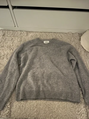 Stickad tröja Zara  - Super mysig tröja från Zara. Den är i 70% ull och 30% Kashmir. Super mysig och använt den max 1 gång. Färgen är grå/blå 