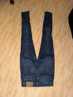 Mörkblå Tiger of Sweden jeans skinny - Säljer ett par mörkblå jeans från Tiger of Sweden med skinny passform. Klassisk femficksmodell med snygga detaljer och bruna sömmar. Jeansen har låg midja och är tillverkade i stretchigt denim för en tajt och bekväm känsla.
