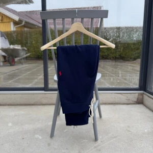 Ralph Lauren byxor - Marinblå, Det är i bra skick men… OBS! Dem är modifierade (se bild 3 & 4) Resorbandet bortplockat, de har alltså sprättats upp, plockat bort resorna och sedan sytt upp kanten igen, detta gjordes för att få en, enligt mig, bättre passform, byxorna ser mer relaxed ut. Detta har alltså jag gjort själv. Orderbekräftelse från Zalando finns. 