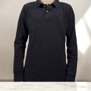 Långärmad piké Ralph lauren - Polo Ralph lauren långärmad piké i mörkblå i storlek 14-16 med passar nån som är ungefär 155-165cm lång. Tröjan har en rött broderad logga. Perfekt för en tidlös och stilren look. Tveka inte på att höra av dig! Priset är inte hugget i sten.  ✅Skick 9/10🍃👌🏻 ✅Storlek 14-16/155-165 ✅Snabba leveranser ✅Snabba svar ✅100% bomull     ‼️Skicka prisförslag‼️