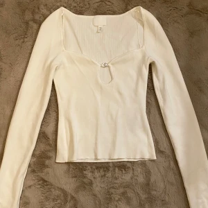 Vit långärmad topp med pärldetalj - Krämvit, fin, långärmad topp men pärla vid urringningen