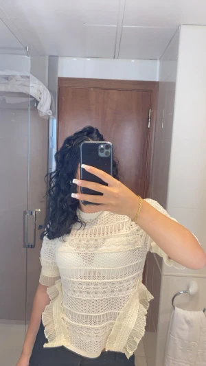 zara blus - Säljer en superfin vit blus med spetsdetaljer och volanger längs sidorna. Blusen har korta ärmar och är tillverkad i ett genombrutet spetsmaterial som ger en romantisk vibe. Perfekt för dig som gillar detaljer och vill sticka ut lite extra.