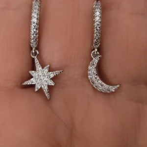  Helt nya Silvriga örhängen med stjärna och måne - Unika silvriga örhängen i 925 sterling silver med glittriga stenar. Ena örhänget har en stjärnformad hängande detalj och det andra en måne, båda täckta av små gnistrande stenar. Perfekt för dig som gillar himmelsinspirerade smycken med extra bling.