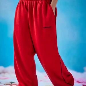 Röda mjukisbyxor Iets frans - Röda mjukisbyxor från Iets Frans harri med svarta piping längs sidorna, elastisk midja och fickor både fram och bak. Byxorna har en loose passform och är perfekta för en chill och avslappnad stil.