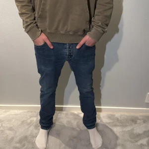 Jacob cohën jeans - Säljer ett par blå jeans från Jacob cohën med klassisk femficksdesign och snygga slitningar. Jeansen har rak passform och normal midja, med ett broderat J på bakfickan. Perfekta för dig som gillar stilrena och bekväma jeans. Modellen på bilden är 186 lång och väger 70kg