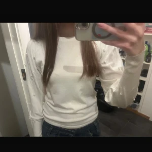 Vit tröja med pärldetaljer på ärmar - Säljer en jätte fin långärmad tröja med snygga pärldetaljer på ärmarna. 