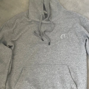Grå hoodie från Christian Dior - Säljer en grå hoodie från Christian Dior i storlek L. Tröjan har huva med snörning, en stor magficka och diskret Dior-logga broderad på bröstet. Materialet är mjukt och känns som bomull, perfekt för chill dagar. Enkelt och stilrent plagg som funkar året runt. Storlek L men passar även jättebra på dig som har M