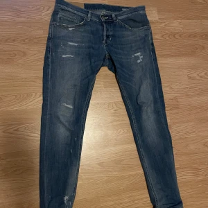 Blåa Dondup george  - Snygga blå skinny jeans från Dondup i storlek 31. Jeansen har slitna detaljer. Materialet är en mix av bomull och polyester som ger stretch och bekväm passform. Perfekt för dig som gillar en smal siluett.