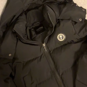 Svart pufferjacka från Trapstar M - Säljer en svart pufferjacka från Trapstar i storlek M. Köpt för ungefär 2 år sen använd i bra skick inget som är trasigt har tyvärr inget kvitto kvar 