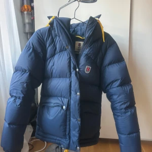 Blå Fjällräven jacka expedition down lite - Mörkblå pufferjacka från Fjällräven. Köpt för 7499. Perfekt för kalla dagar och har en riktigt mysig vibe. Extremt bra skick, använd sparsamt. Storlek S.
