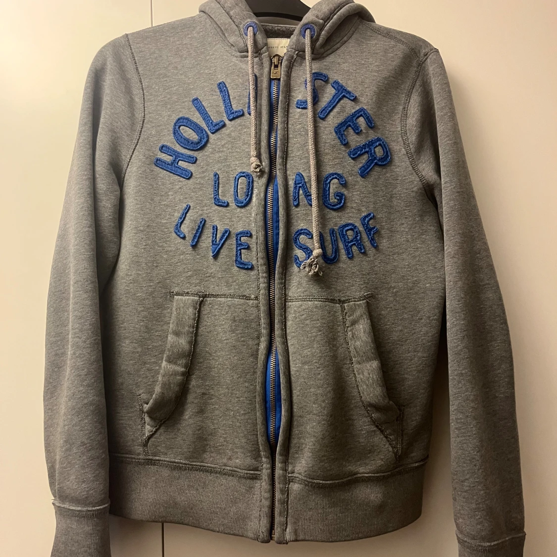 Grå hoodie från Hollister med blå text